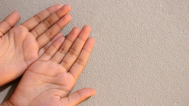 Photo of two small children's hands looking up