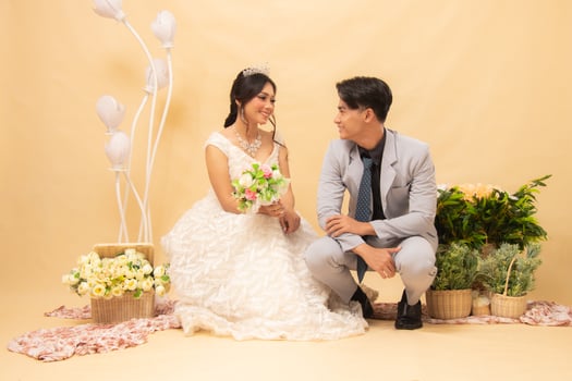 male and female couple poses sitting looking at each other intimately indoor photo shot. couple wedding national bride studio
