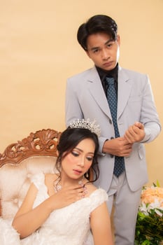 elegant male and female couple standing poses relaxed smiling slightly looking forward male hands holding suit buttons intimately indoor photo shot. couple wedding national bride studio