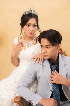 elegant male and female couple poses sitting on lounge chairs all smiling spoiled looking forward intimately indoor photo shot close up. couple wedding national bride studio