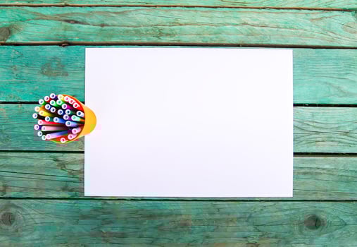 White paper sheet and school supplies on wooden aged background. photo
