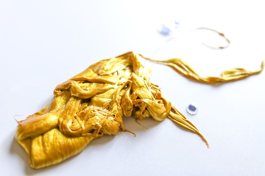 Golden plasticine soft stretchable texture. Anti-stress toy for kids activities, handmade, fun. photo