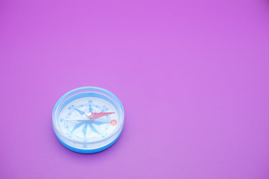 round compass isolated on purple background. photo