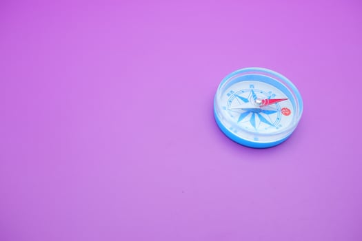 round compass isolated on purple background. photo