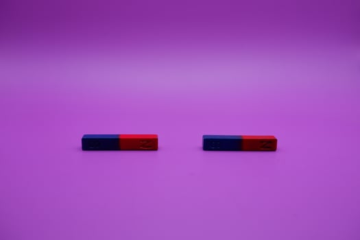 two bar magnets isolated on a purple background photo