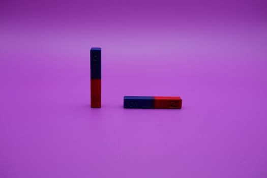 two bar magnets isolated on a purple background photo