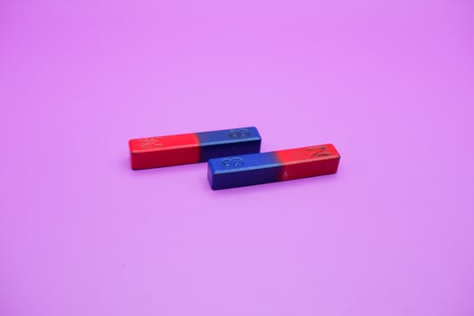 two bar magnets isolated on a purple background photo
