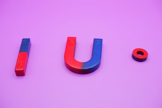 various shapes of magnets isolated on a purple background photo