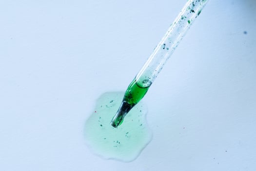 dropper pipette with green liquid isolated photo