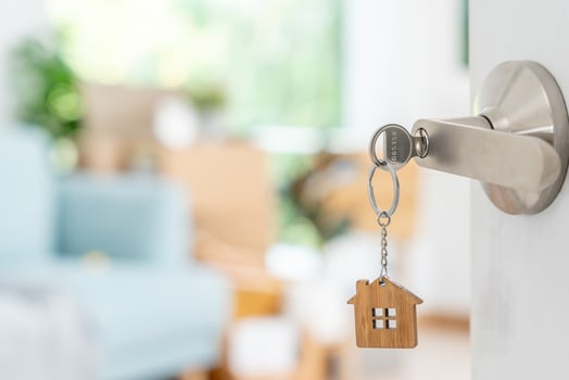 Moving house, relocation. The key was inserted into the door of the new house, inside the room was a cardboard box containing personal belongings and furniture. move in the apartment or condominium photo