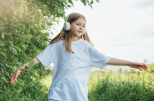 A child with headphones listening to music and dancing photo