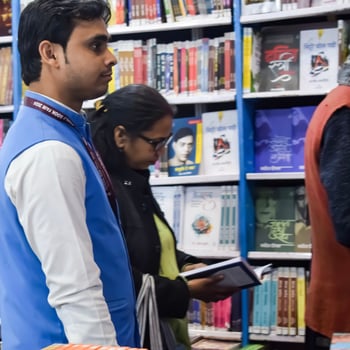 Delhi, India, June 7 2024 - Various age group people reading variety of Books on shelf inside a book-stall at Delhi International Book Fair, Books in Annual Book Fair at Bharat Mandapam complex photo