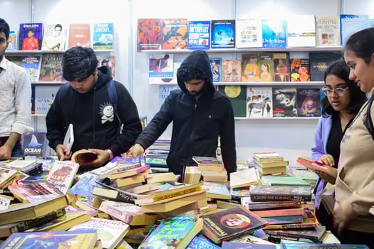 Delhi, India, June 7 2024 - Various age group people reading variety of Books on shelf inside a book-stall at Delhi International Book Fair, Books in Annual Book Fair at Bharat Mandapam complex photo