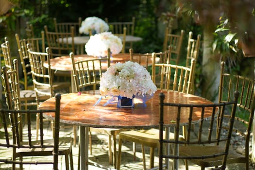 a table with chairs and flowers in a garden photo