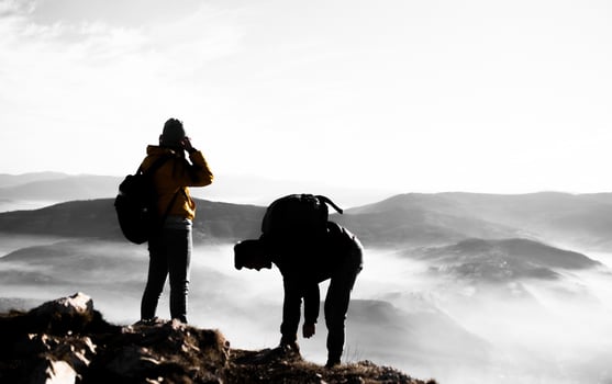 happy couple man and woman tourist at top of mountain during a hike in summer photo