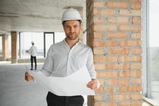 Portrait of man architect at building site. Confident construction manager wearing hardhat. Successful mature civil engineer at construction site with copy space. photo