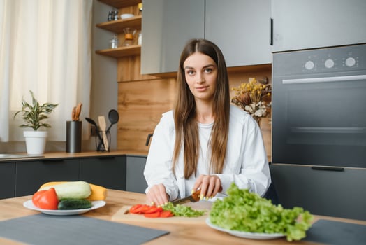 Beautiful European woman preparing a toast of vegetables and microgreens. Nutritionist teaches healthy eating. The vegetarian diet raw food. Dinner of modern people. Cooking sandwich. Girl happy cook. photo