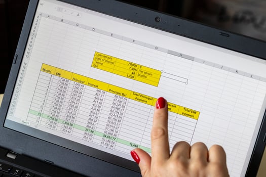 Close up shot of the woman with beautiful hands and manicure, working on the laptop, scrolling touch screen with mortgage loan amortization table open. Banking photo