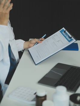 A beautiful and professional Asian female doctor is working on her medical cases on her laptop or making a call medical consultation with a patient while sitting in her office. photo