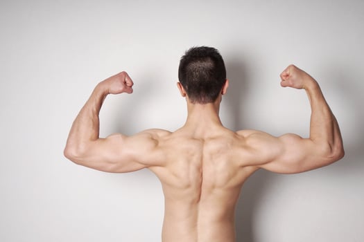 man flexing biceps and back muscles photo