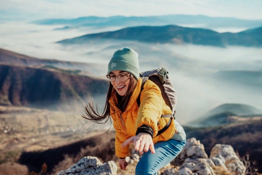 People helping each other hike up a mountain at sunrise. photo