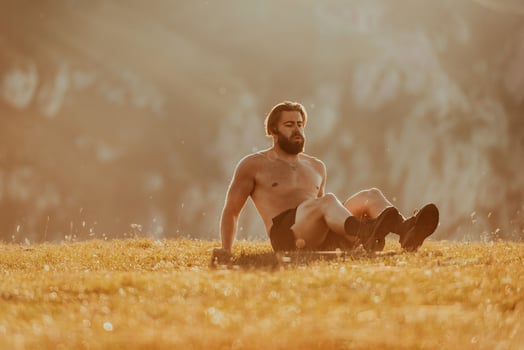 A man doing abs exercises on top of a mountain photo