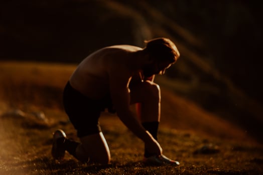A determined athlete preparing for the start of training on the top of the mountain at sunrise. photo