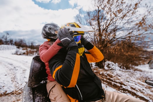 Couple enjoying while driving quad bike on top of mountain at winter time photo