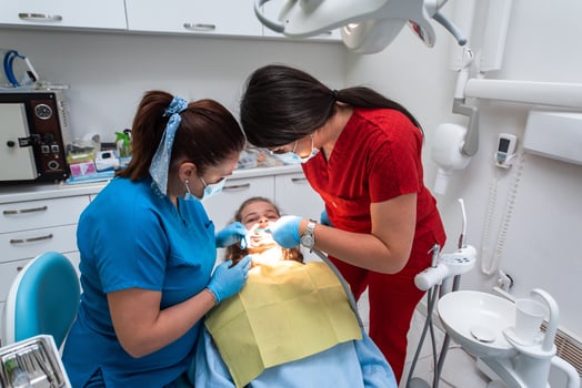 Dentist appointment at a dental clinic, placing braces locks on the teeth and pulling the archwire to fix it photo