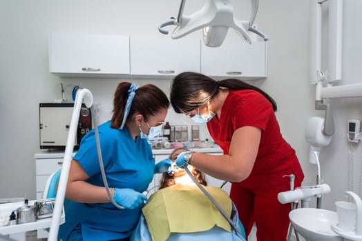 Dentist appointment at a dental clinic, placing braces locks on the teeth and pulling the archwire to fix it photo