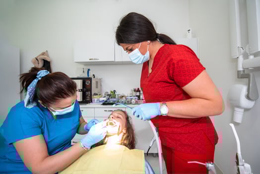 Dentist appointment at a dental clinic, placing braces locks on the teeth and pulling the archwire to fix it photo