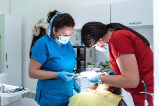 Dentist appointment at a dental clinic, placing braces locks on the teeth and pulling the archwire to fix it photo