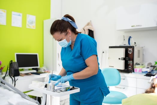 Dentist appointment at a dental clinic, placing braces locks on the teeth and pulling the archwire to fix it photo