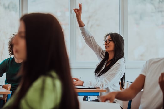 A black-haired female student wearing glasses is attentively engaged in a modern classroom, embracing education and learning with focus and curiosity photo