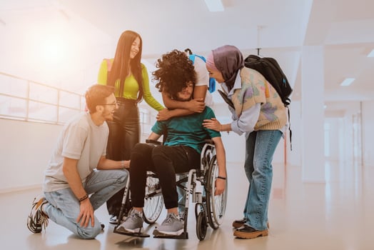 In a modern university, a diverse group of students, including an African American student and a hijab-wearing woman, walk together in the hallway, accompanied by their wheelchair-bound colleague photo