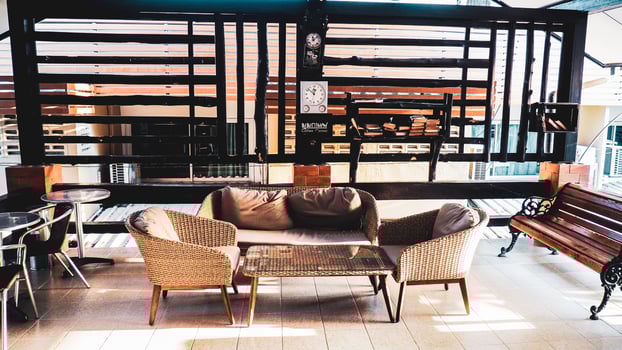 Cozy Outdoor Seating Area with Wicker Furniture and Modern Wooden Partition in a Sunlit Patio photo