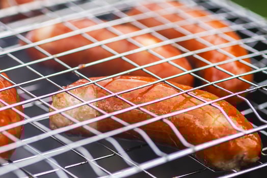 Tasty grilled sausages. Frying on brazier outdoors in the countryside at summer. photo