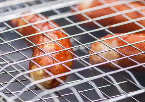 Tasty grilled sausages. Frying on brazier outdoors in the countryside at summer. photo