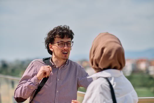 After a day at the office, a business man engages in conversation with his Muslim colleague wearing a hijab photo