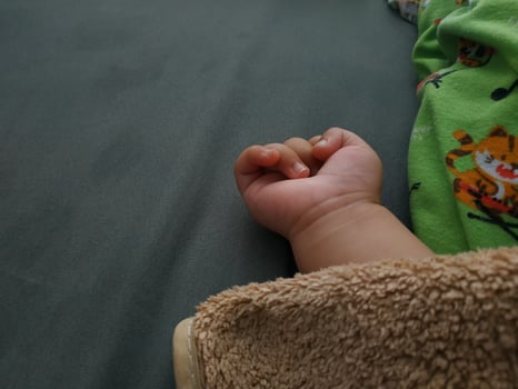 baby's hand on the mattress, close up photo
