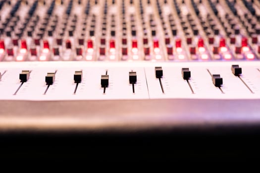 Control panel board desk with sliders and motorized faders in professional recording studio, mixing console used in editing records. Switchers, knobs and buttons used in production. Close up. photo