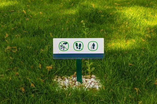 Sign do not walk on the lawn do not litter and pluck plants photo