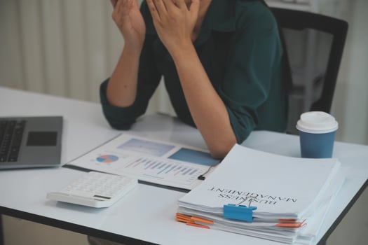 Asian women sitting in a home office With stress and eye strain.Tired businesswoman holding eyeglasses and massaging nose bridge. There are tablets, laptops, and coffee. photo