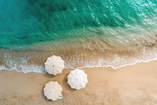 Top view of an umbrella on a tropical sandy beach. Blue, turquoise transparent water surface of the ocean, sea background with copy space. Holidays and summer vacation empty banner photo