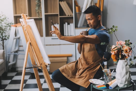 Young male artist painting picture in studio photo