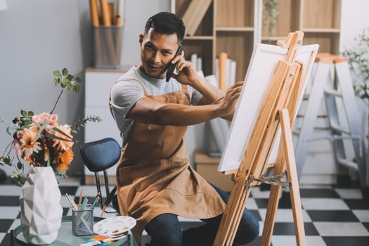 Young male artist painting picture in studio photo