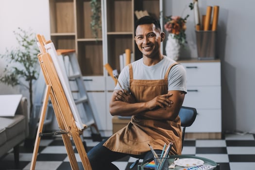 Young male artist painting picture in studio photo