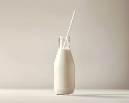 a glass bottle with milk and a straw photo