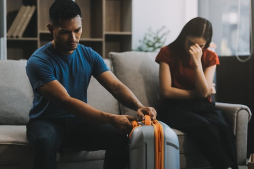 Family couple ignoring each other after a quarrel. Two people turn away and don't talk to each other. Angry young man and woman sitting back to back, with arms crossed on the sofa in the living room photo