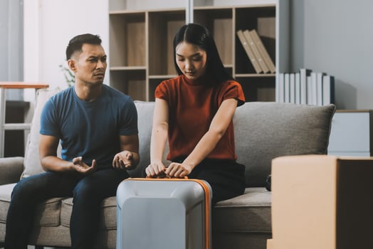 Family couple ignoring each other after a quarrel. Two people turn away and don't talk to each other. Angry young man and woman sitting back to back, with arms crossed on the sofa in the living room photo